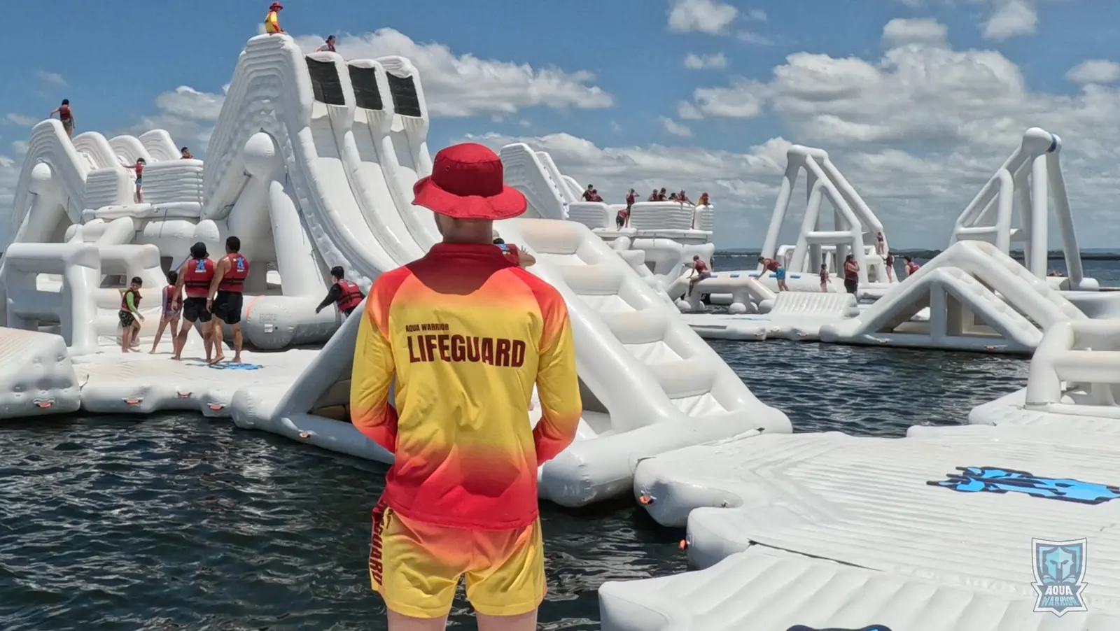 Aqua Warrior lifeguard supervising guests across the inflatable water park